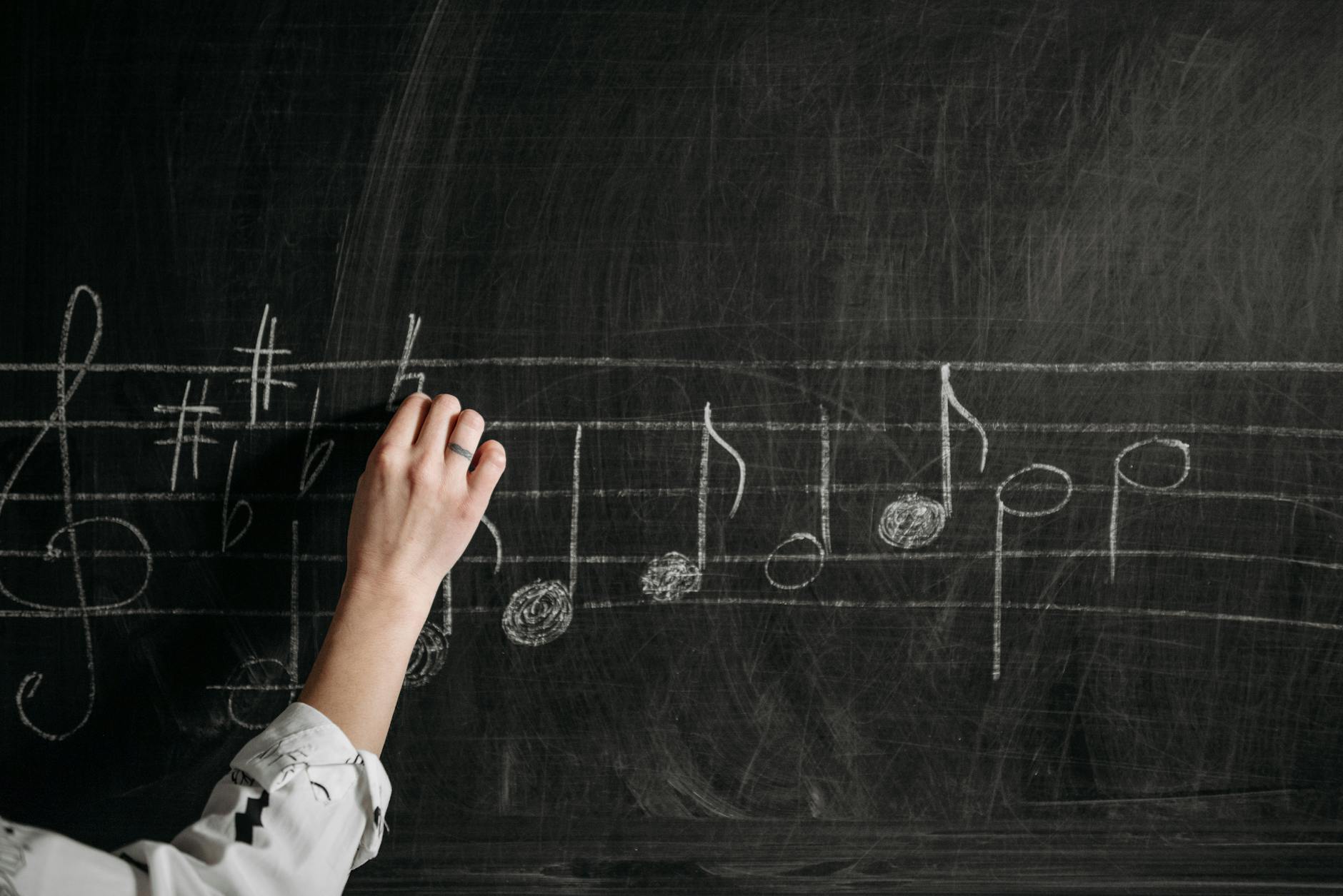 person writing on a black board